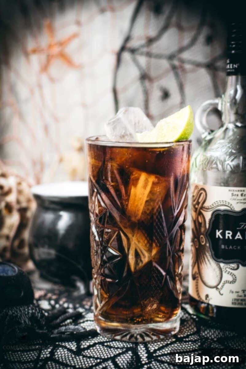 Gorgeous highball glass filled with delicious Kraken Cola. Served spookily next to a little spider on a spider web.