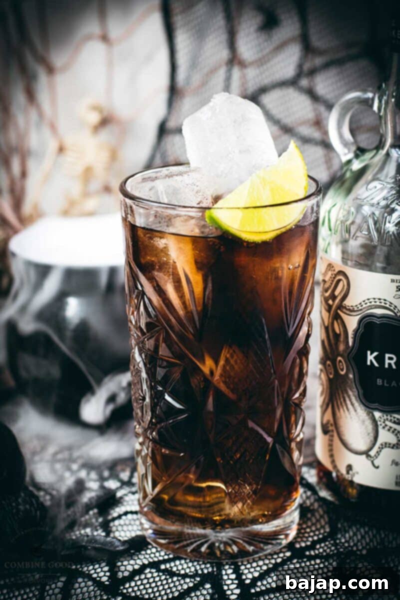 Gorgeous highball glass filled with delicious Kraken Cola. Served spookily next to a little spider on a spider web.