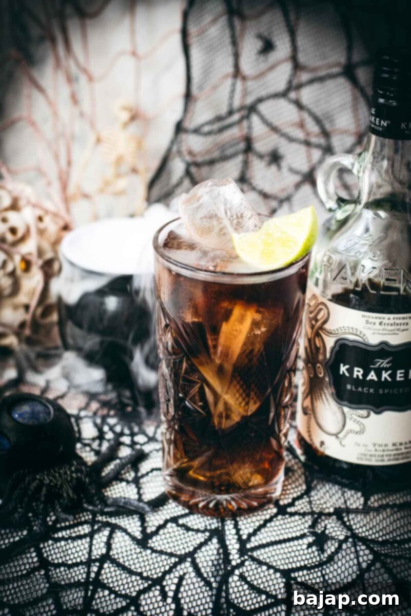 Gorgeous highball glass filled with delicious Kraken Cola. Served spookily next to a little spider on a spider web.