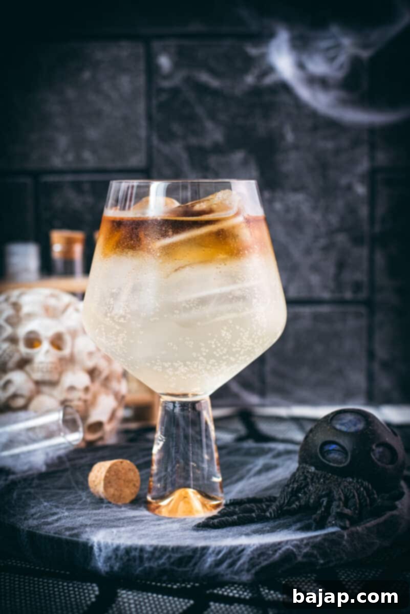 Gorgeous layered kraken ginger beer cocktail with spooky decoration, perfectly layered.