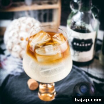Gorgeous layered kraken ginger beer cocktail with spooky decoration.
