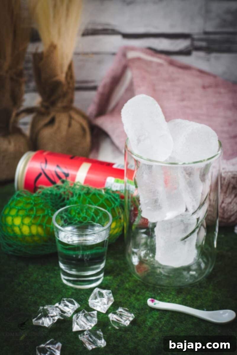 Ingredients for Cuba Libre cocktail: rum, coke, lime, and cubed ice, laid out on a dark surface.