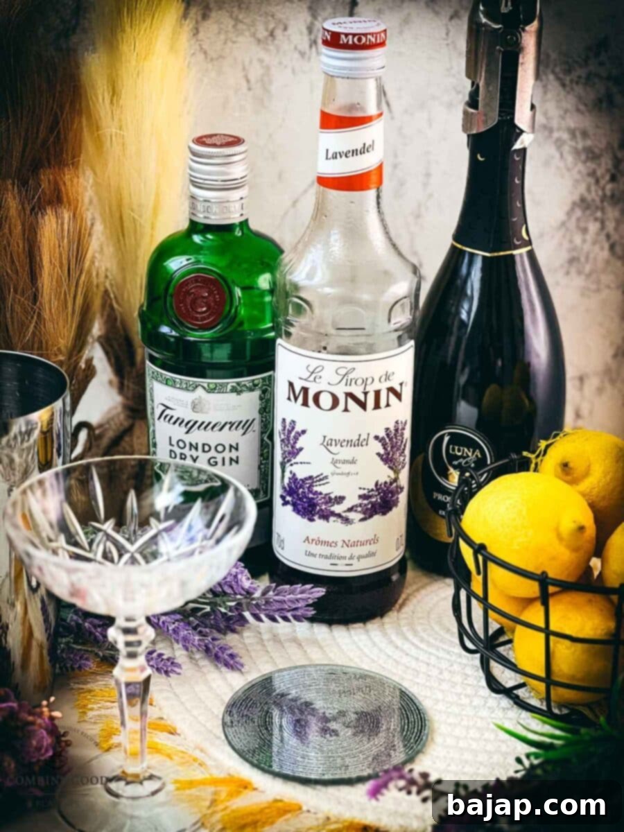 Ingredients for a lavender gin Prosecco cocktail including lavender syrup, gin, lemon juice, cubed ice, and a bottle of Prosecco.