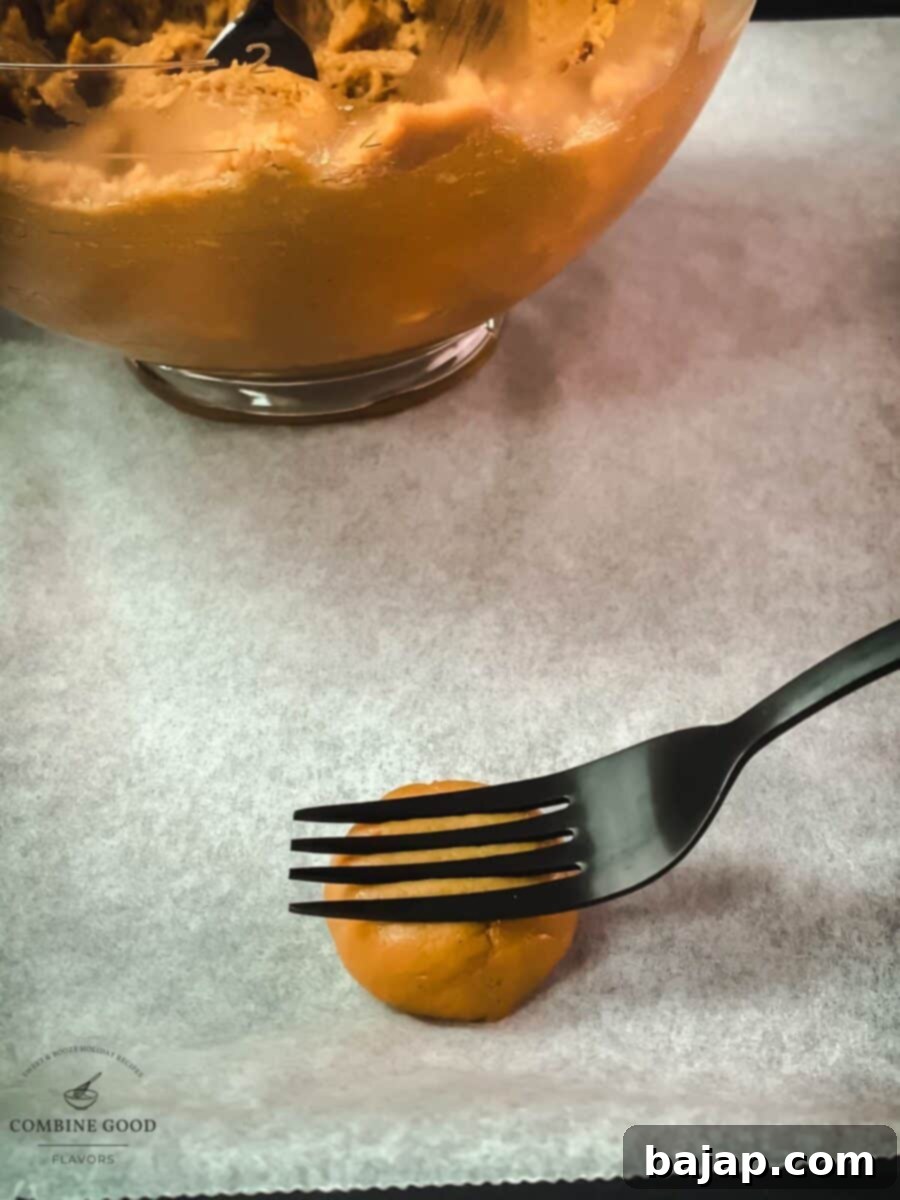Creating the signature crisscross pattern on peanut butter cookie dough with a fork before baking.