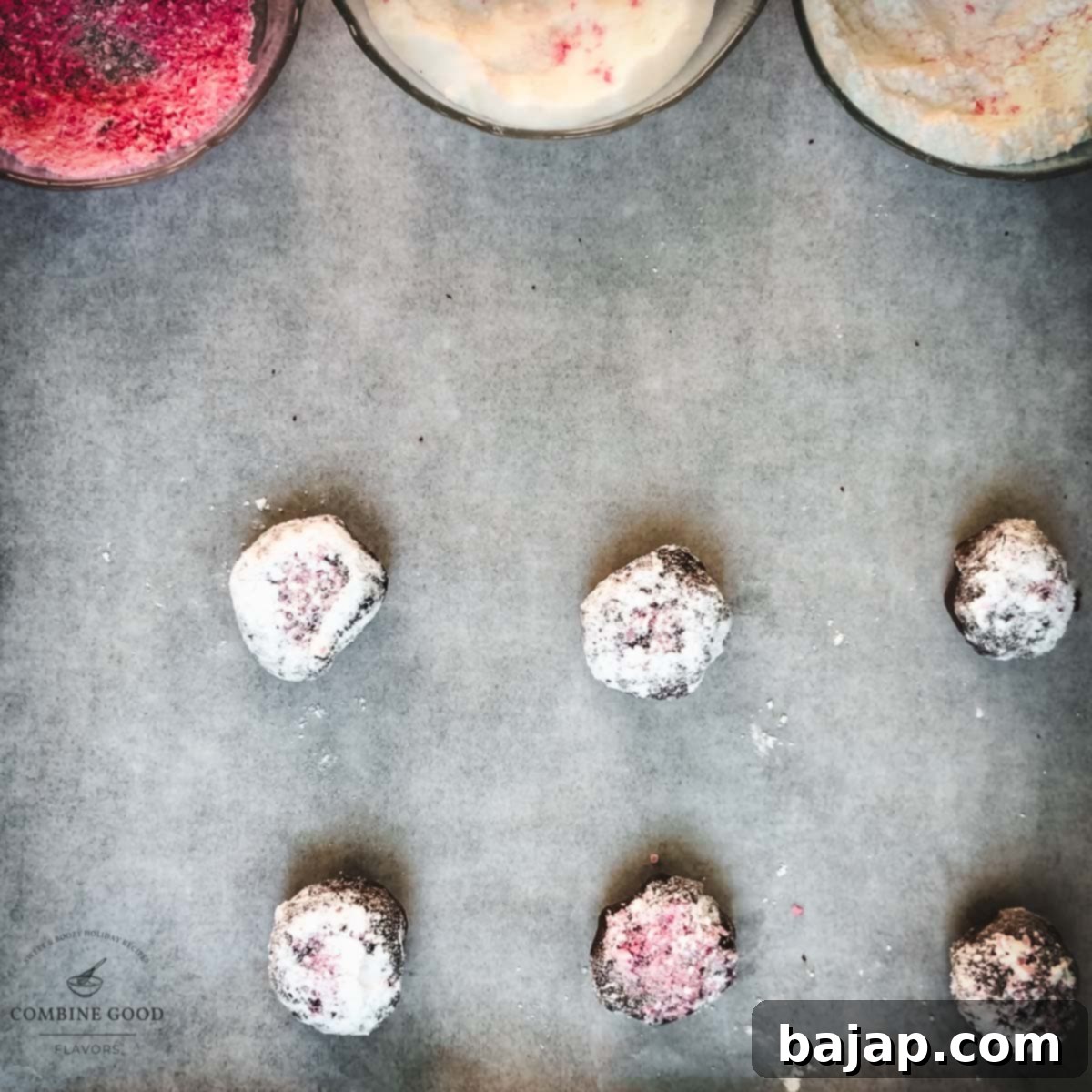 Minty Chocolate Crinkle Delights 17 Sugar and candy cane coated chocolate peppermint cookie dough balls arranged on a baking sheet lined with parchment paper, spaced for even baking.