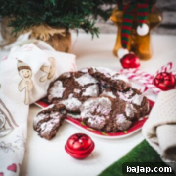 Gorgeous chocolate peppermint crinkle cookies placed on christmassy plate.