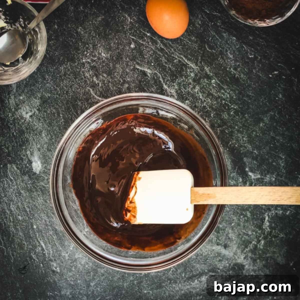 Bowl with melted chocolate and spatula.
