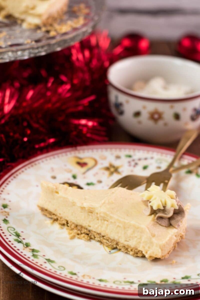 Close-up of a slice of delicious Christmas cheesecake, showing the creamy filling, crunchy vanilla crescent crust, and festive white chocolate snowflake topping.
