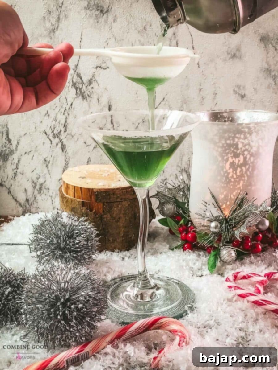 Fine strain the cranberry peppermint martini into the sugar rimmed martini glass.