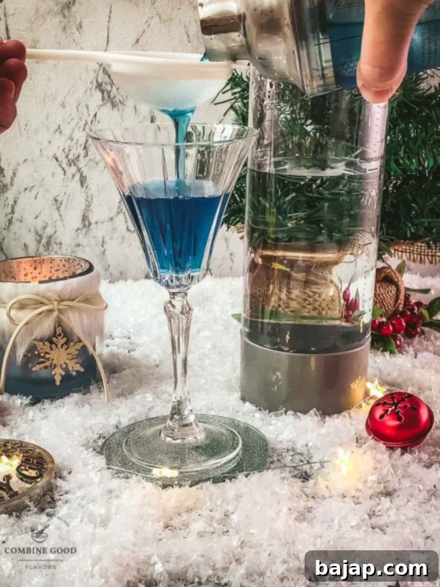 Fine strain the blue Christmas cocktail into your cocktail glass.