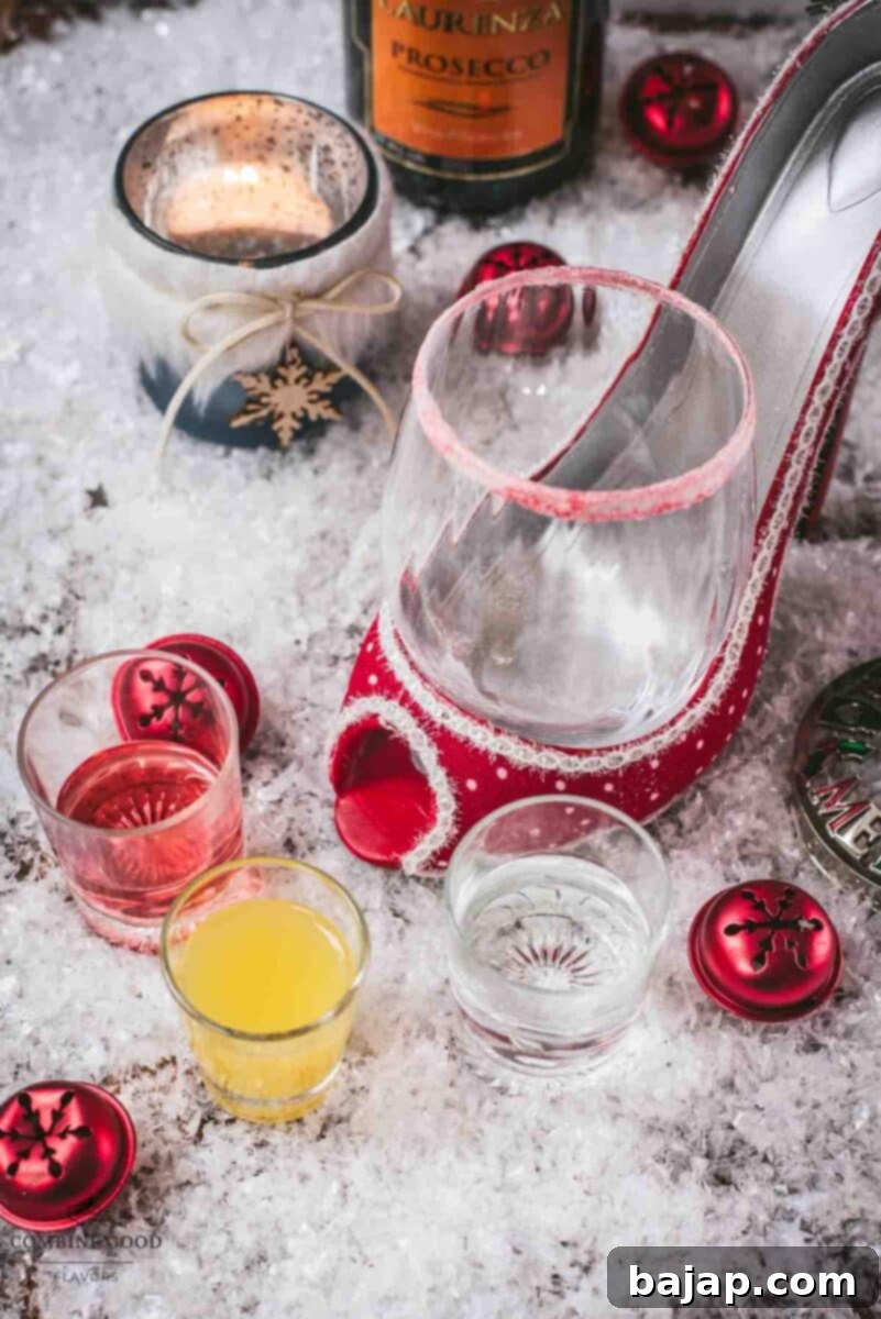 Ingredients for Vodka Cranberry Spritzer: a bottle of vodka, a carton of orange juice, a bottle of cranberry juice, and a bottle of Prosecco, arranged neatly on a festive wooden surface.