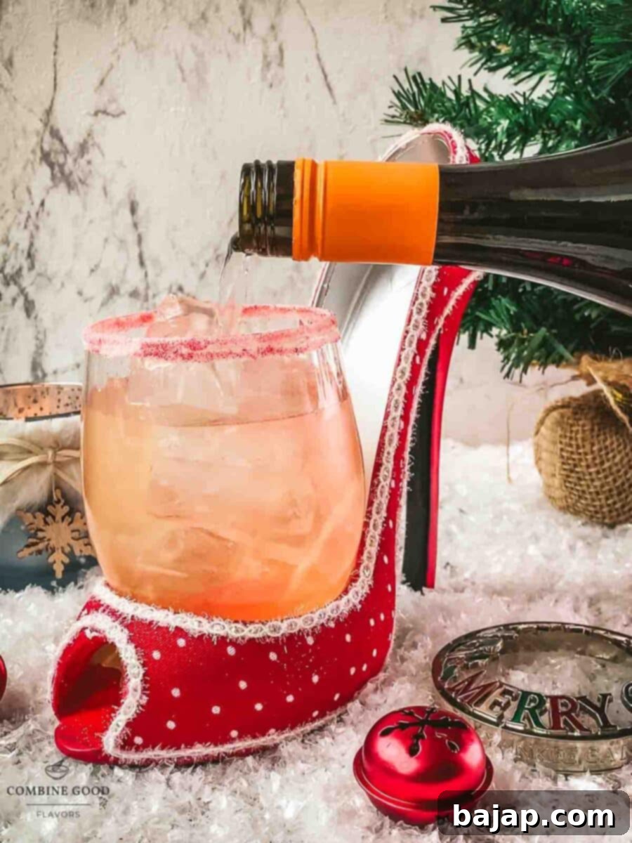 Topping the cocktail with sparkling Prosecco, completing the base of the Cranberry Vodka Spritzer.