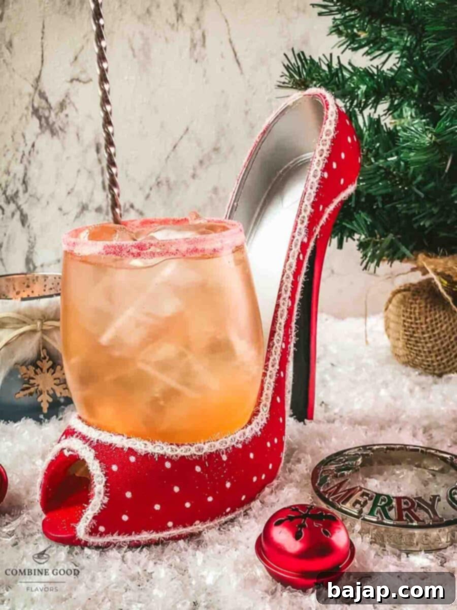 Gently stirring the Cranberry Vodka Spritzer with a bar spoon to combine the flavors.