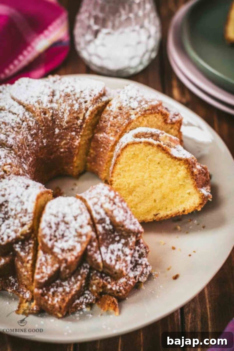 Gorgeous six egg yolk bundt cake, dusted with powdered sugar, and placed on white plate.
