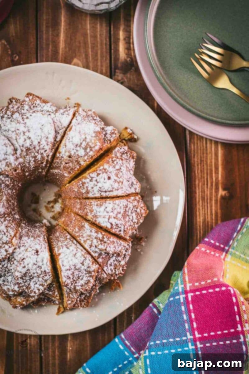 Gorgeous six egg yolk bundt cake, dusted with powdered sugar, and placed on white plate.