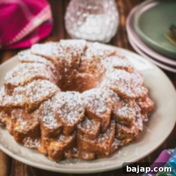Gorgeous six egg yolk bundt cake, dusted with powdered sugar, and placed on white plate.