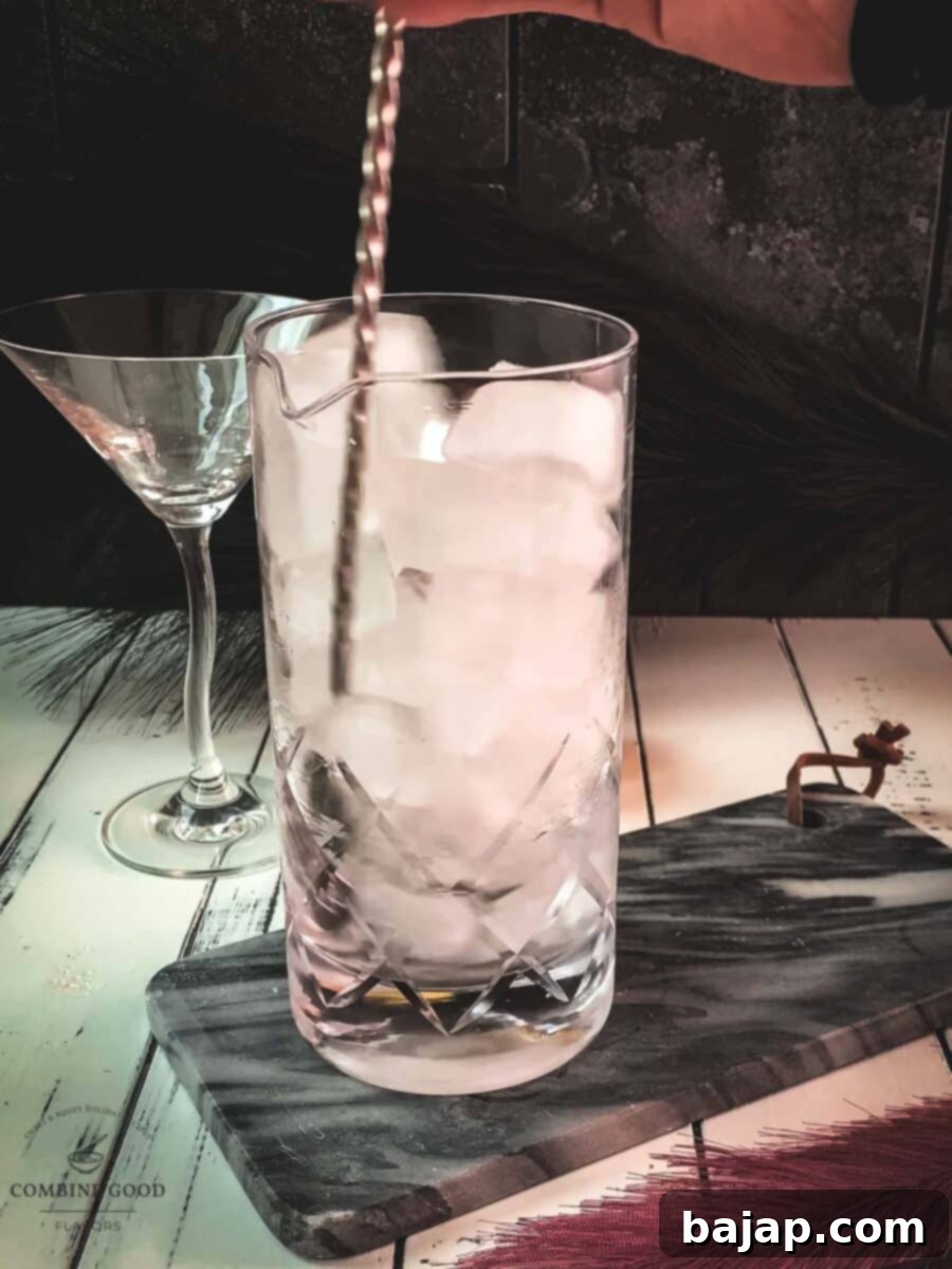 Expertly stirring the martini with a bar spoon, ensuring thorough chilling and a smooth, undiluted consistency.