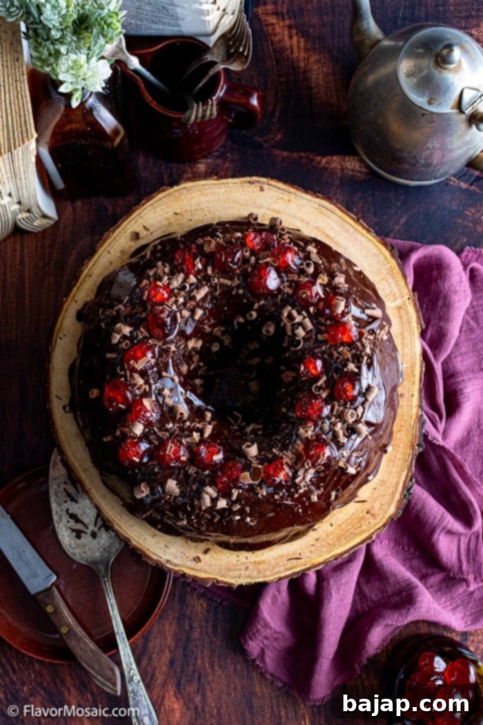 A beautifully glazed Chocolate Cherry Bundt Cake with maraschino cherries on top.