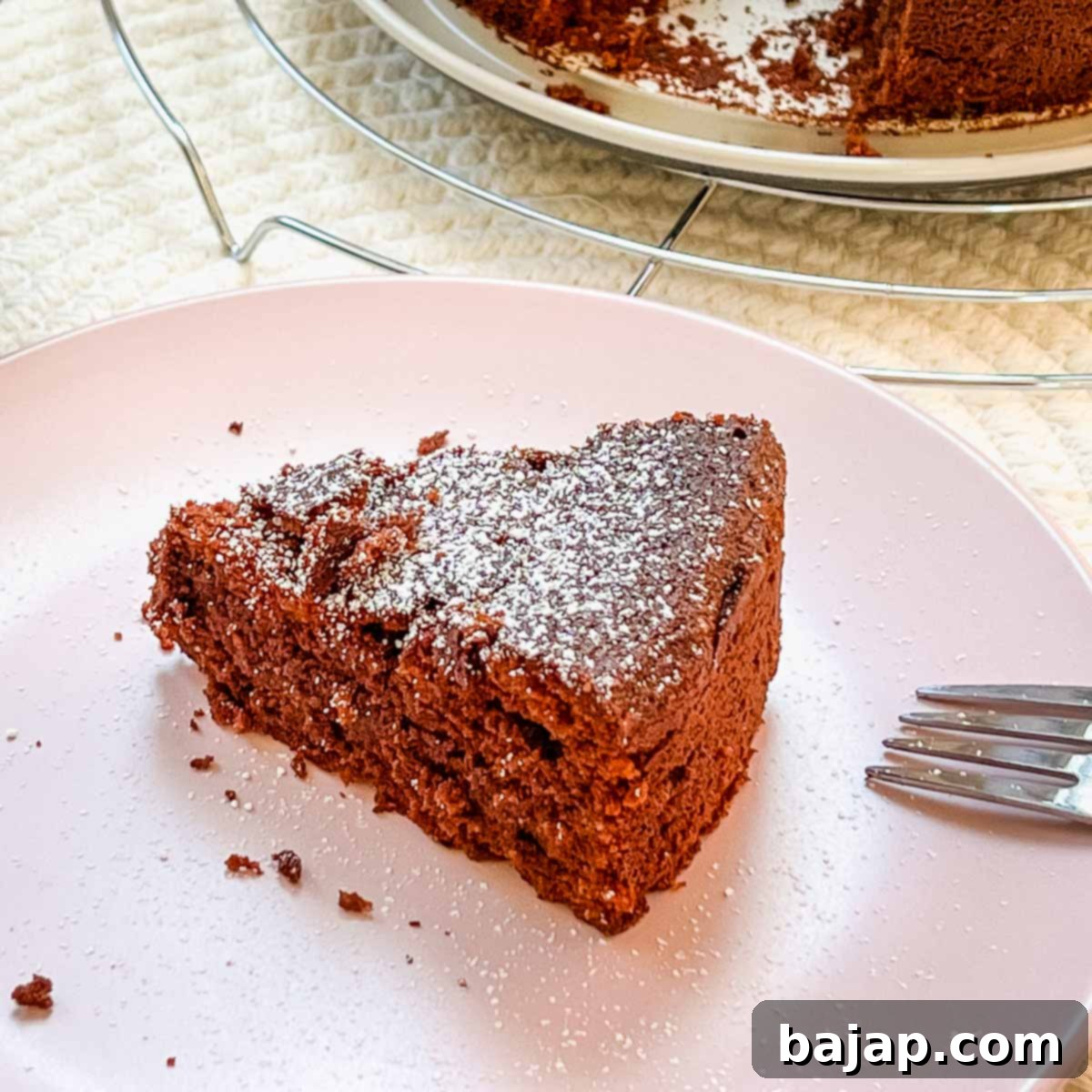A slice of delicious flourless chocolate cake dusted with powdered sugar, ready to be served.