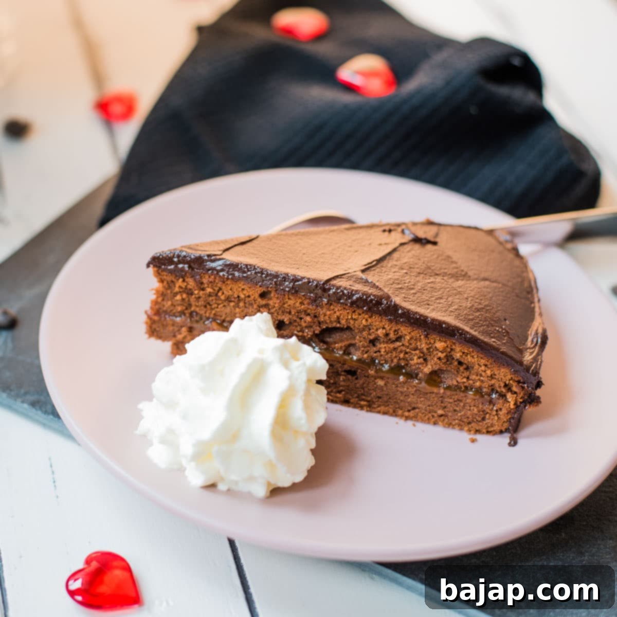 A delicious slice of classic Sacher Torte with a dollop of whipped cream.