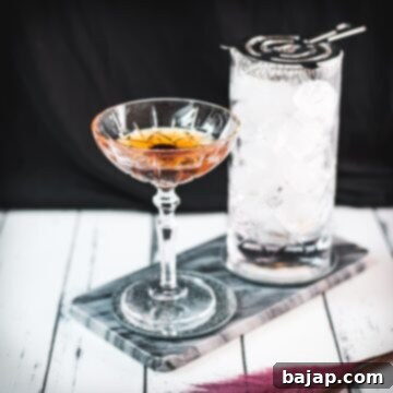 Sophisticated Manhattan cocktail, garnished with a Maraschino cherry, placed on a marbled plate.