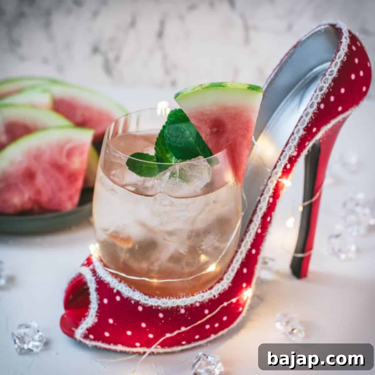 Delicious watermelon spritz with Prosecco placed in a red and white spotted high heel.