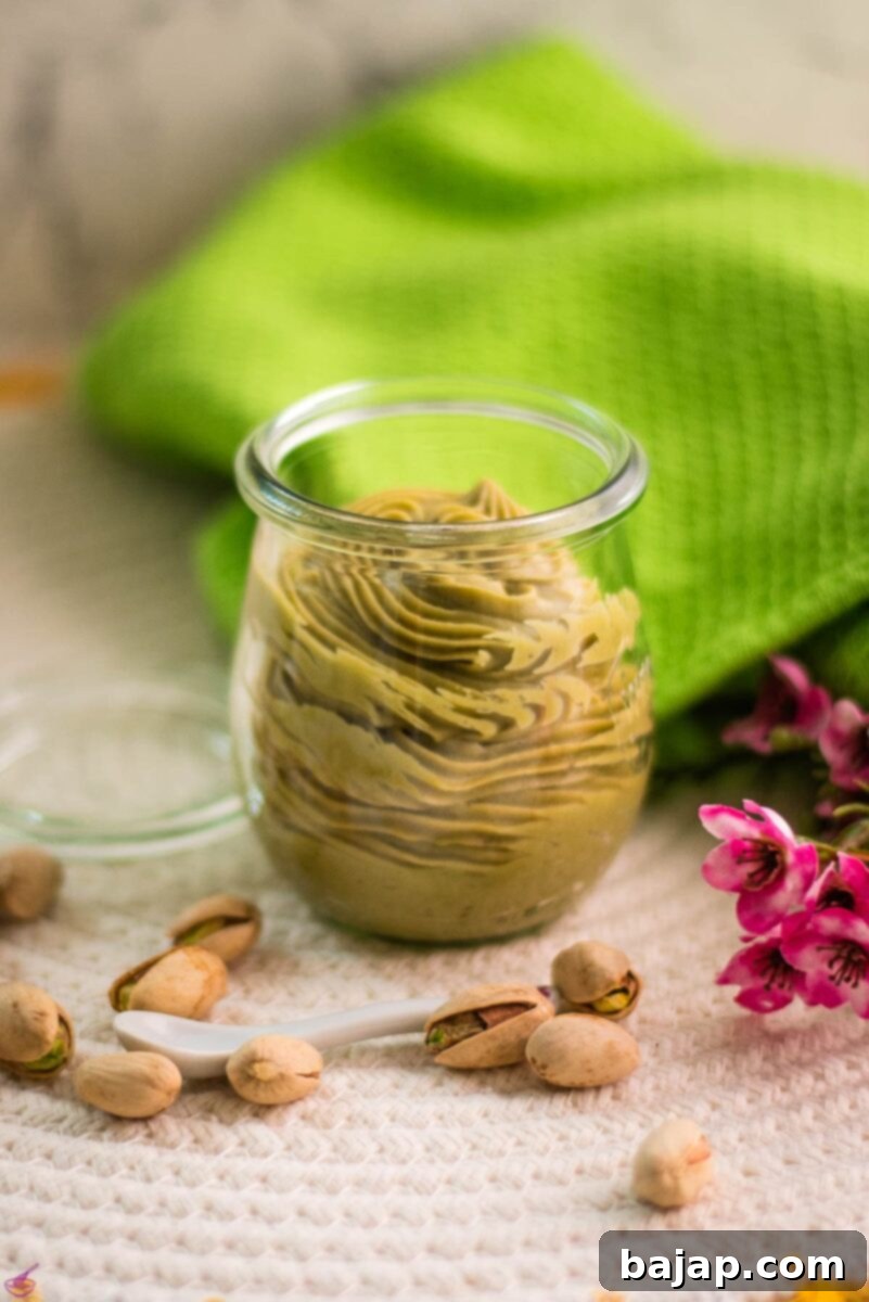 A beautiful preserving glass filled with rich white chocolate pistachio ganache, showcasing its vibrant green color and smooth texture, ready for use.