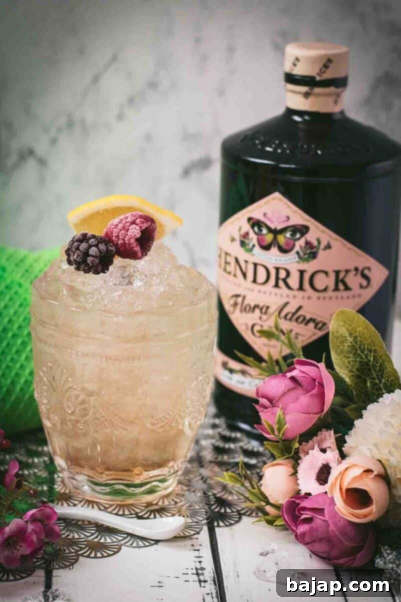 Close-up of a Bramble cocktail, with its vibrant layers of gin, lemon, and blackberry liqueur, garnished with fresh berries and a lemon slice.