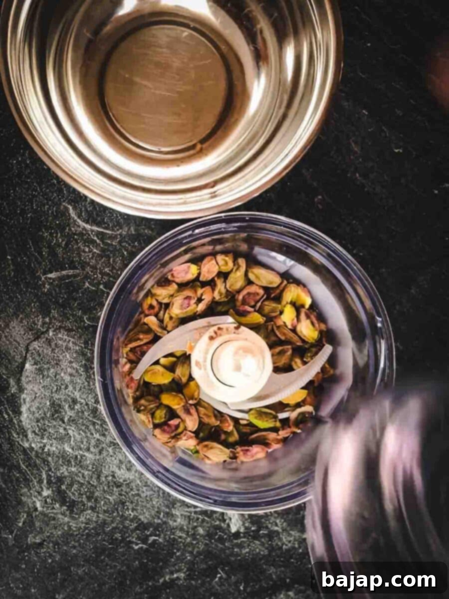 Add the pistachios to the electric chopper.