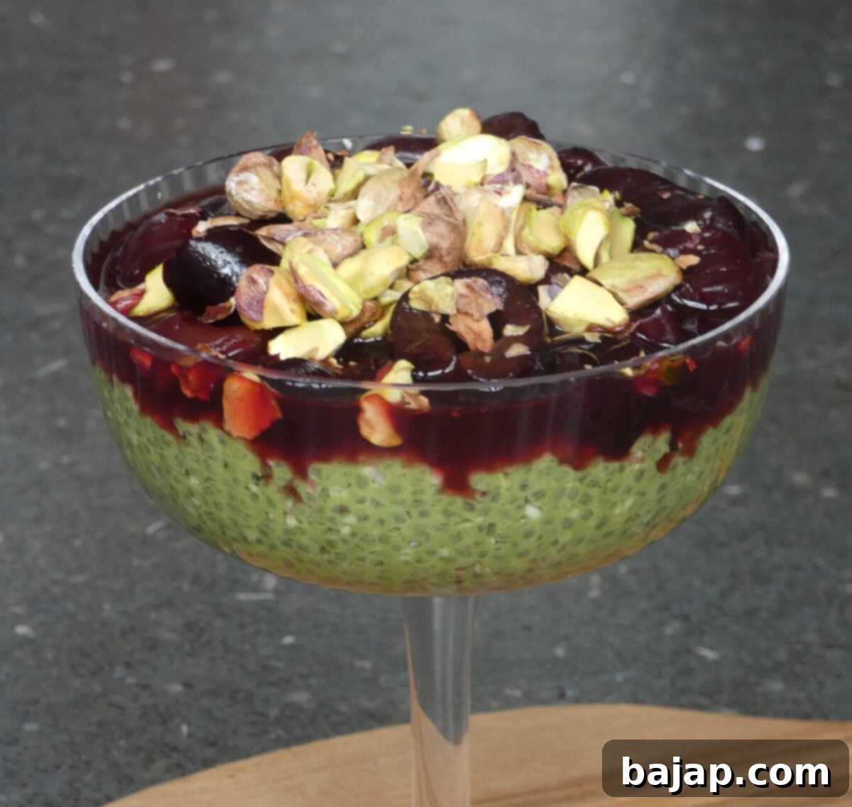 Paleo and vegan matcha chia pudding with hemp seeds, pistachios, and cherries.