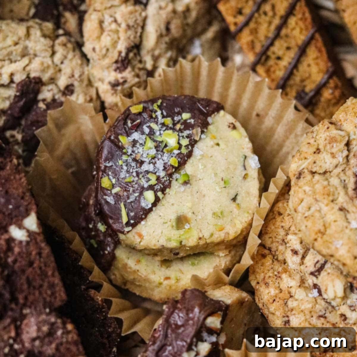 Chocolate-dipped pistachio shortbread cookies with a sprinkle of flaky sea salt.