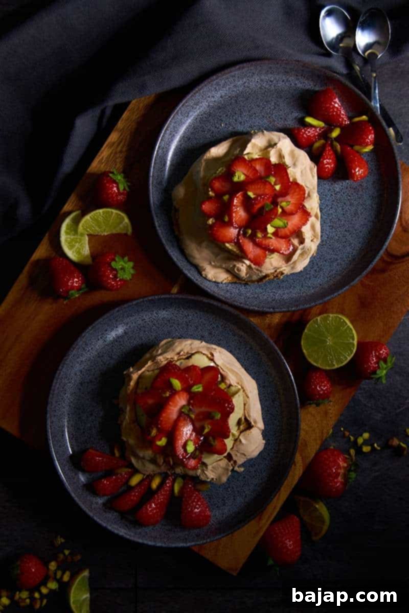 Elegant brown sugar pavlovas topped with light pistachio protein mousse and fresh strawberries.