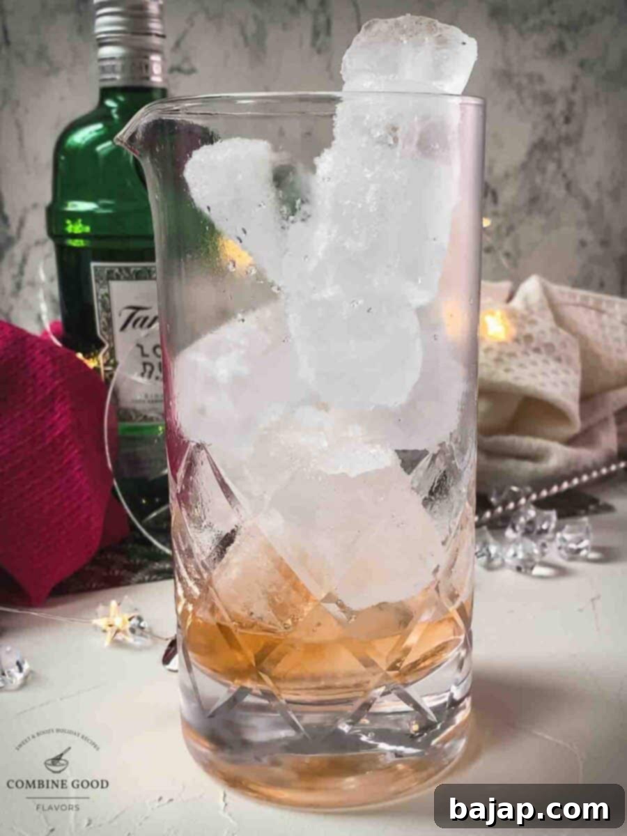 Pouring gin and Angostura bitters into a stirring glass filled with ice, ready for mixing.