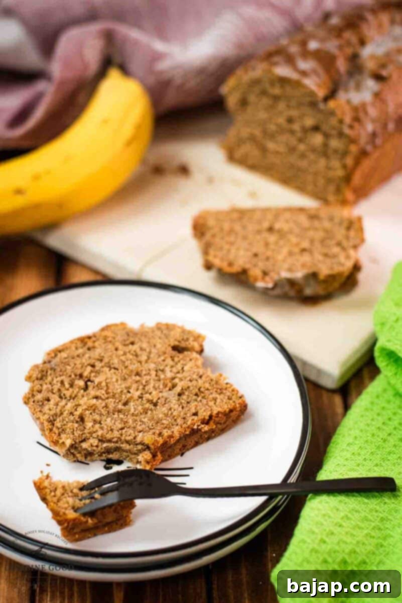 Banana bread slice placed on white plate.
