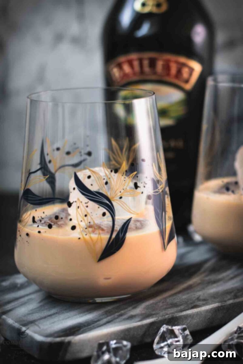 Velvet Frost 2 Two cute tumbler glasses filled with delicious Baileys Irish Cream on the rocks, elegantly placed on a marbled plate for a perfect serving.