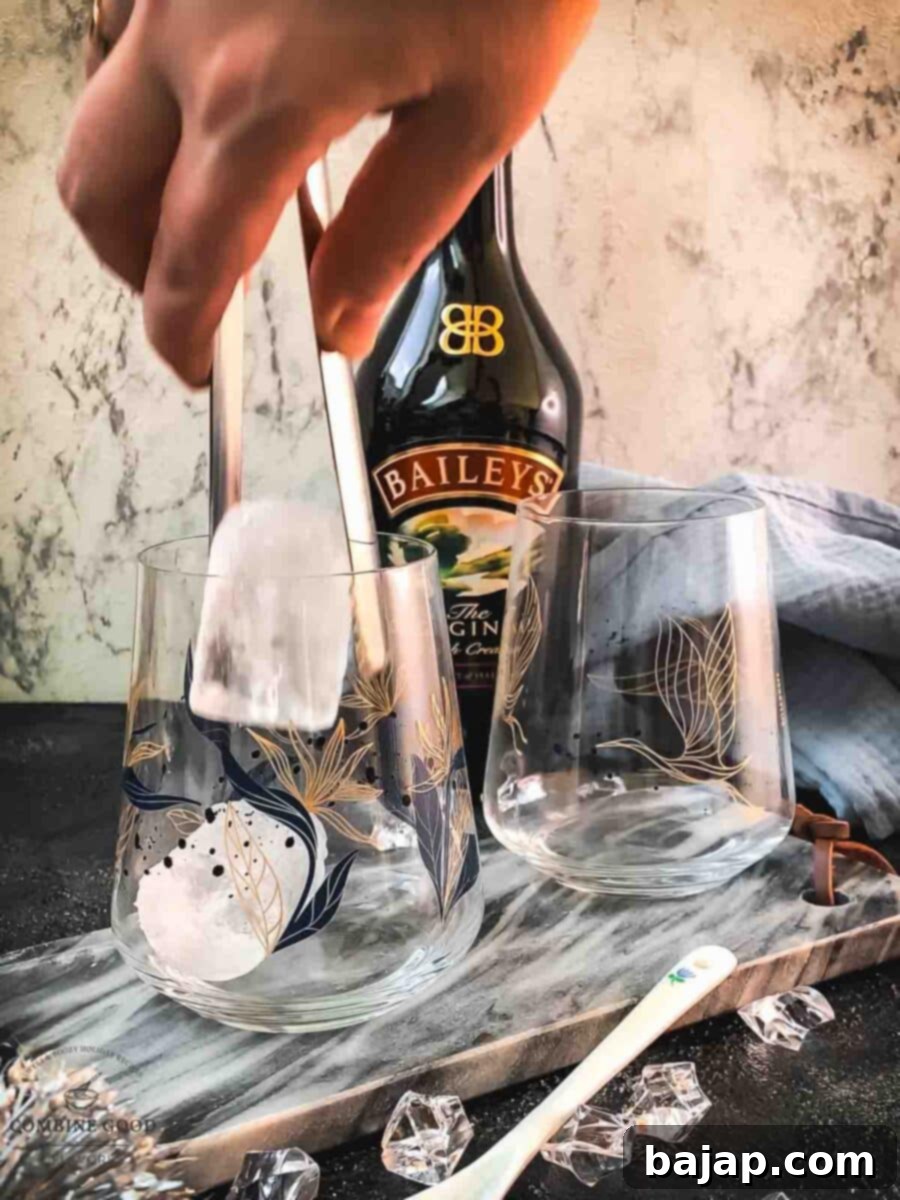 Velvet Frost 3 Carefully adding 2-3 ice cubes into a chilled tumbler glass, ready for Baileys Irish Cream.