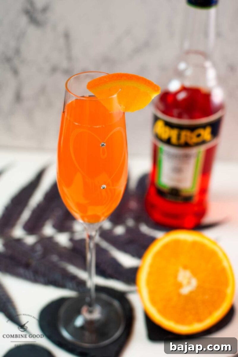Gorgeous sparkling wine glass, with engraved heart and two crystals, filled with delicious Aperol Mimosa. Placed on heartshaped black slate coaster.