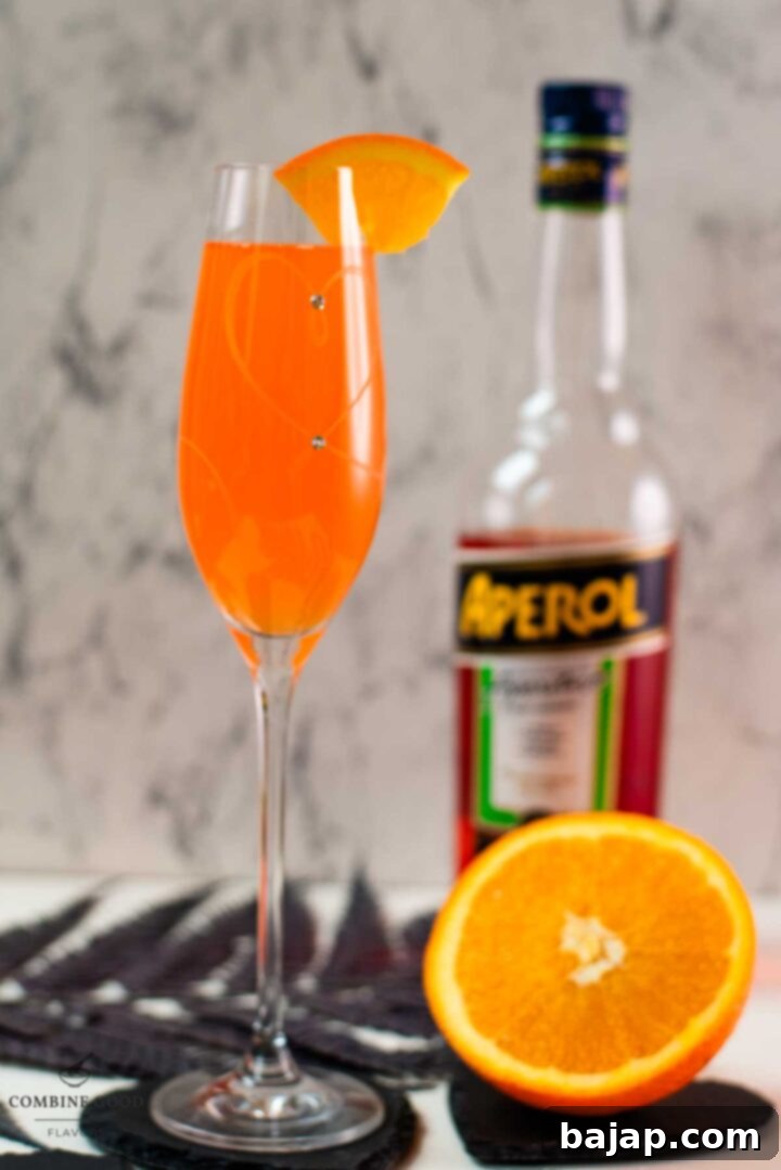 Gorgeous sparkling wine glass, with engraved heart and two crystals, filled with delicious Aperol Mimosa. Placed on heartshaped black slate coaster.