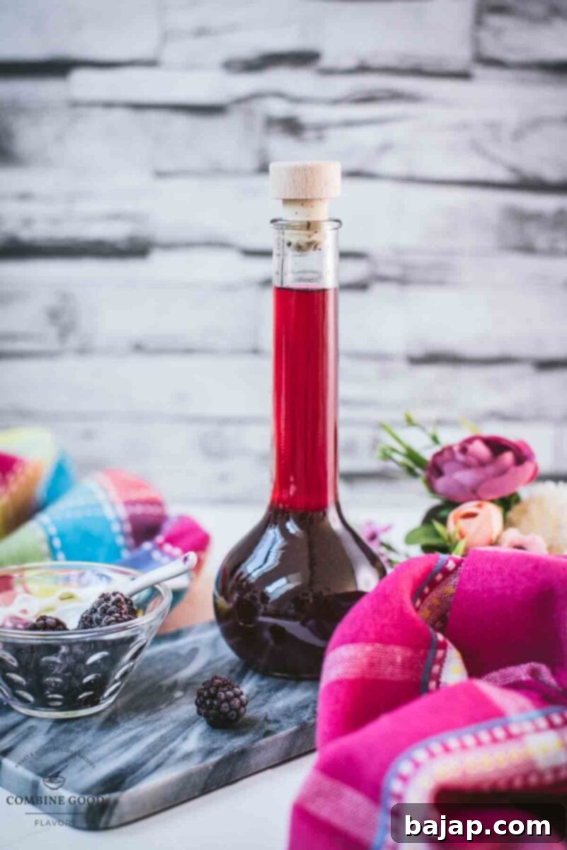Delicious homemade Chambord, blackberry raspberry liqueur, on gorgeous flask, placed on black slate.
