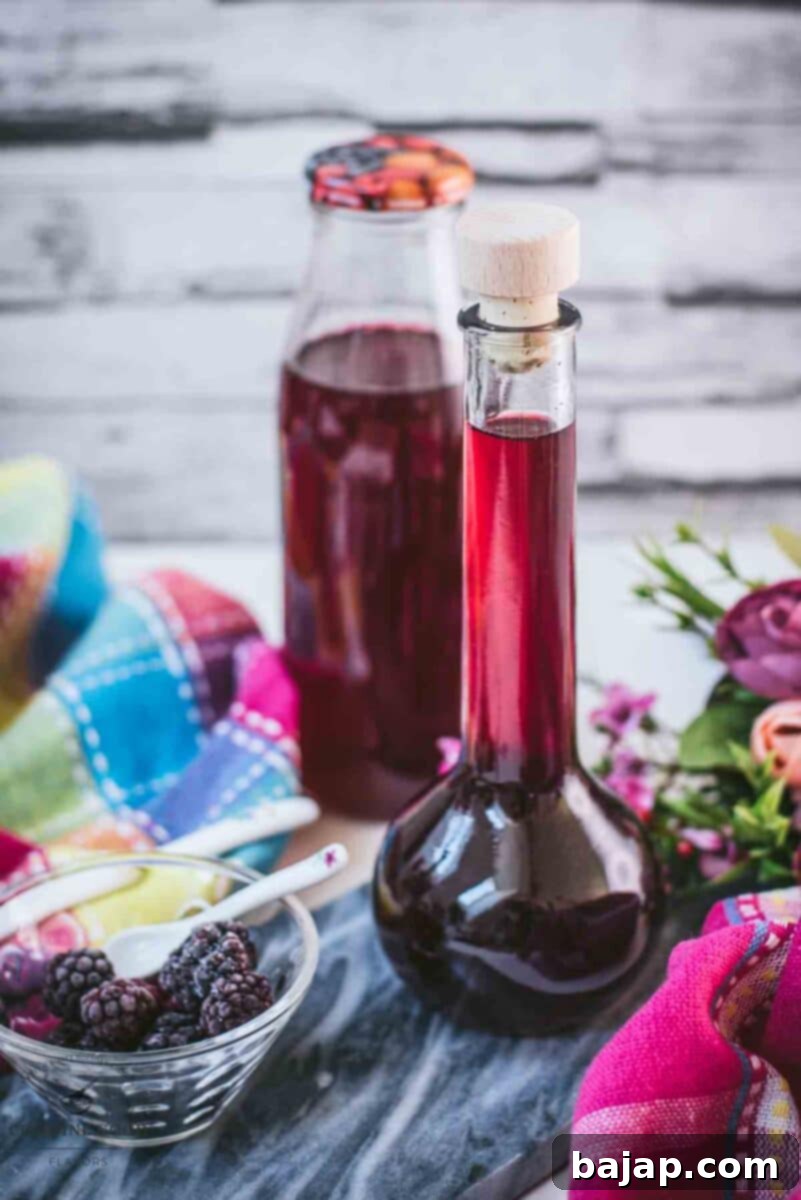 Delicious homemade Chambord, blackberry raspberry liqueur, on gorgeous flask, placed on black slate.