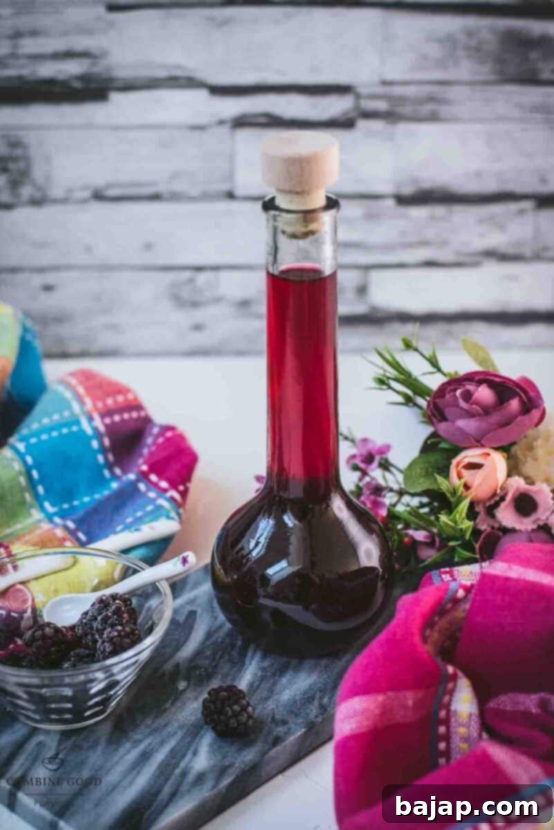 Delicious homemade Chambord, blackberry raspberry liqueur, on gorgeous flask, placed on black slate.