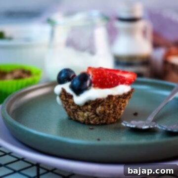 Crunchy Granola Bites 13 Cute little granola cup, filled with yogurt and topped with fresh strawberries, blue grapes, and drizzled with maple syrup. Placed on dark green plate.