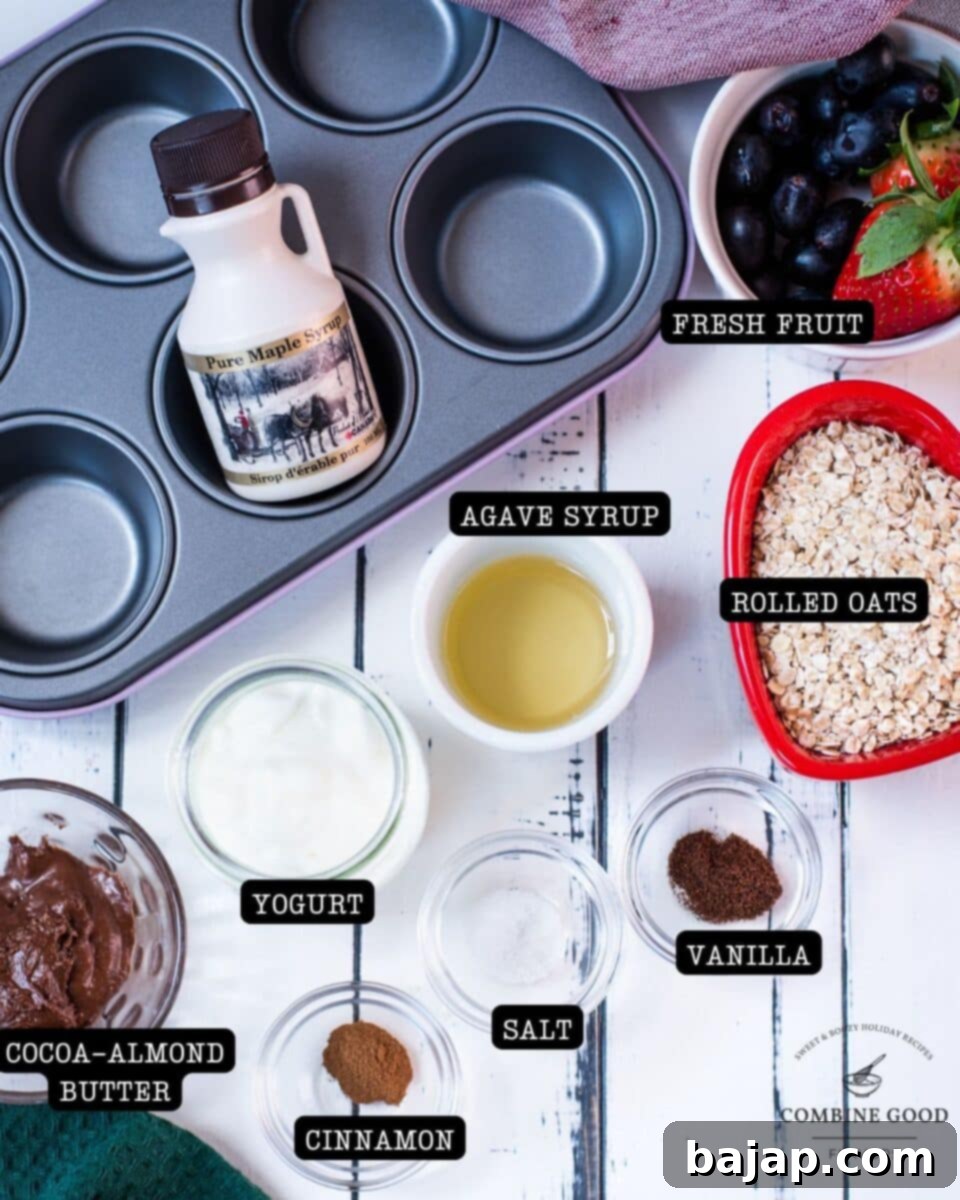 Crunchy Granola Bites 3 A beautiful flat lay of breakfast granola ingredients, including rolled oats, ground cinnamon, ground vanilla, agave syrup, cocoa-infused almond butter, a pinch of salt, fresh natural yogurt, vibrant strawberries, sweet blue grapes, and a bottle of maple syrup, all ready for making delicious granola cups.