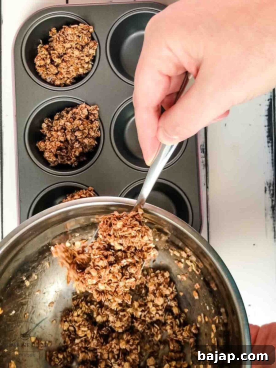 Spoon the granola mix into the muffin tin molds.