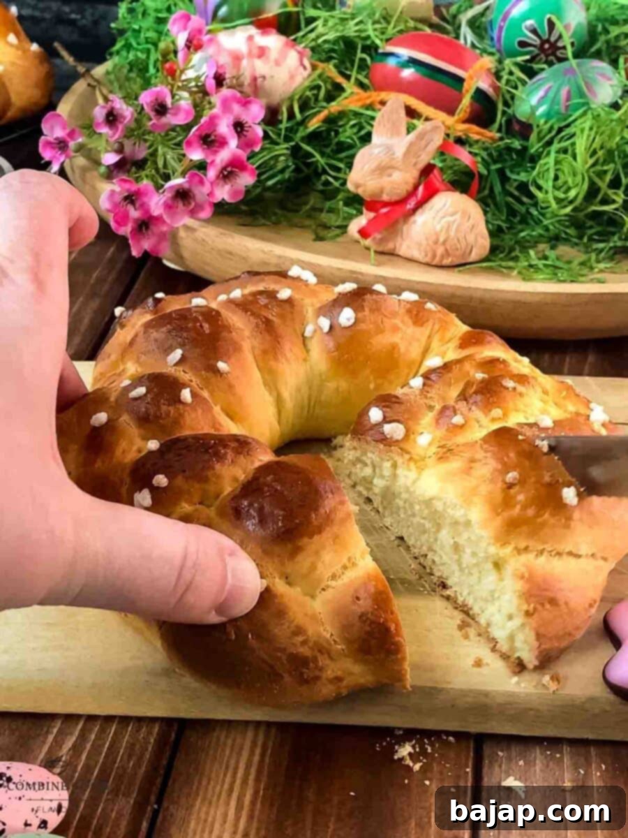 Gorgeous braided Easter bread wreath, placed on wooden cutting board, next to easter decoration.