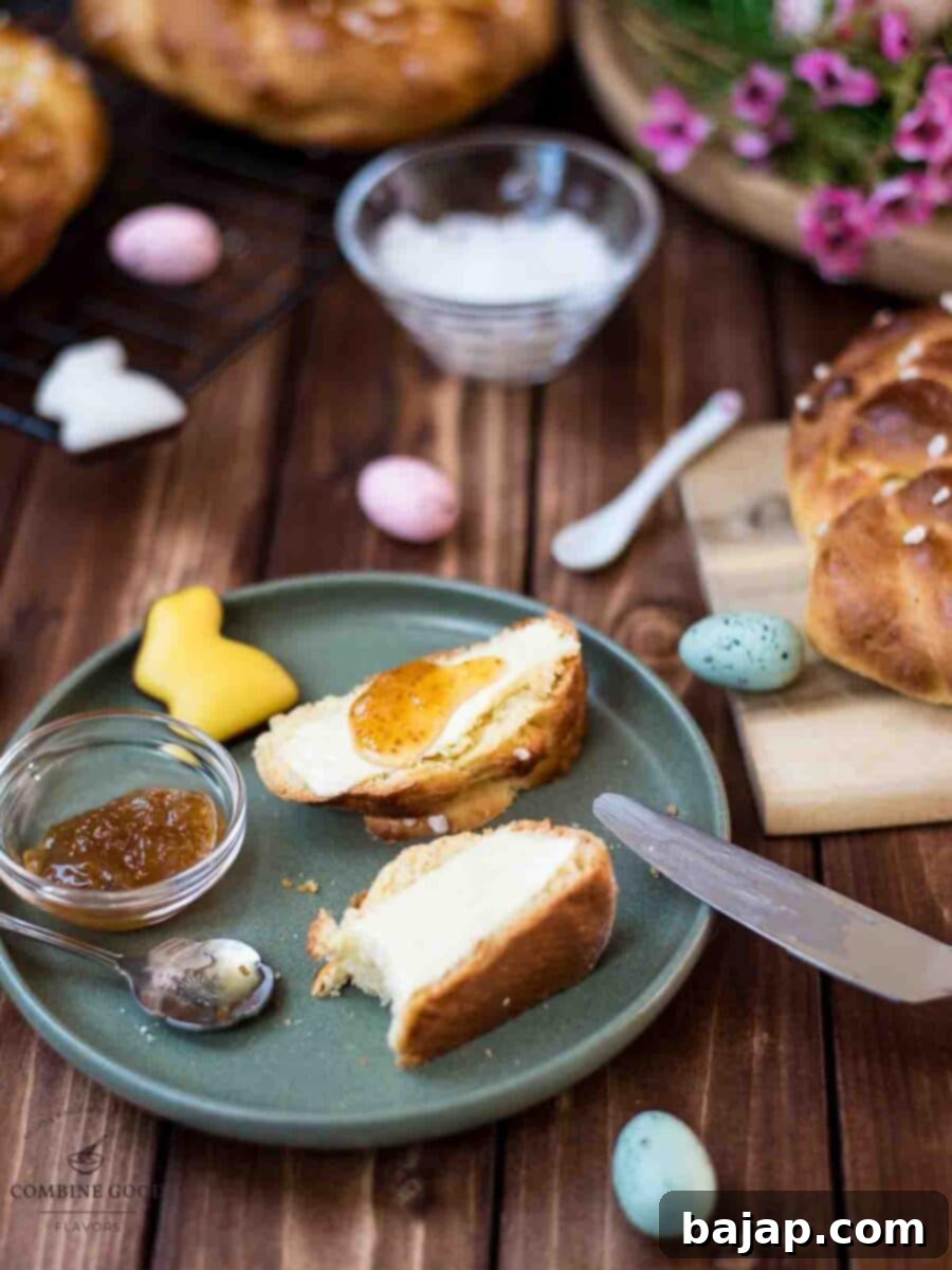 Sliced braided Easter bread wreath with butter and jam placed on green plate, next to Easter decoration.