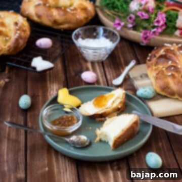 Sliced braided Easter bread wreath with butter and jam placed on green plate, next to Easter decoration, highlighting the soft texture.