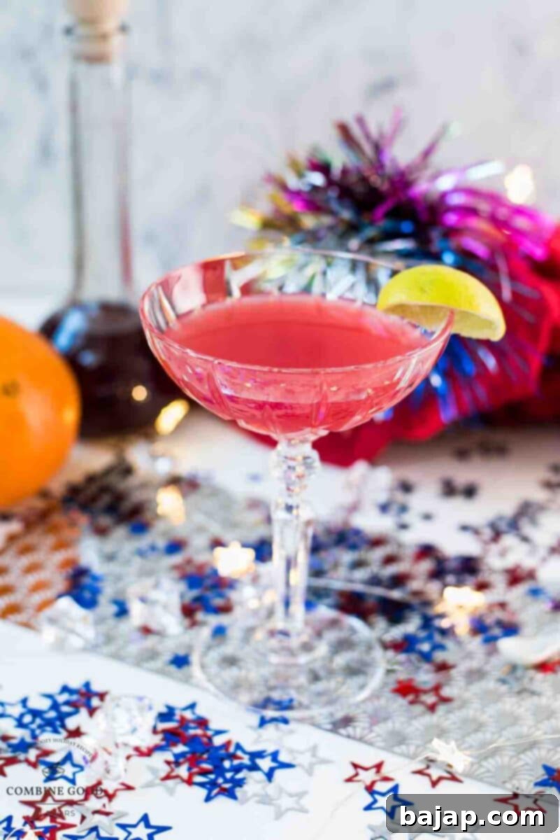 Utterly delicious Fourth of July margarita cocktail in a cocktail glass. Garnished with a lime slice and placed on white ground, covered with red, white and blue confetti stars, capturing the festive spirit.