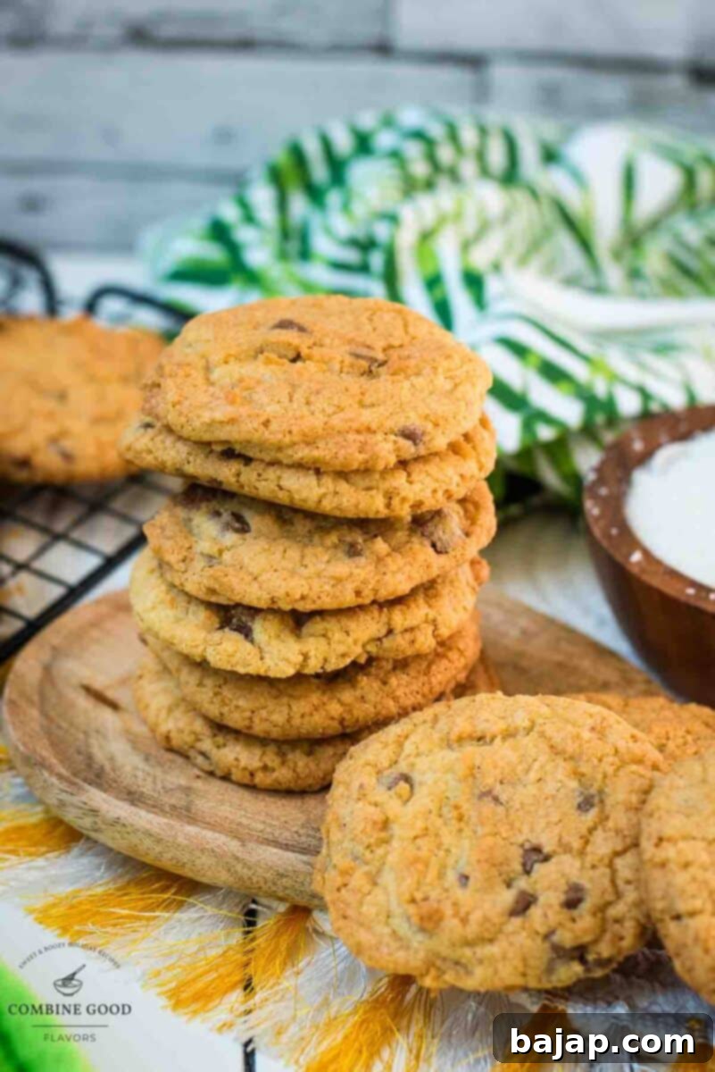 Delicious coconut chocolate chip cookies, stacked on a wooden plate.