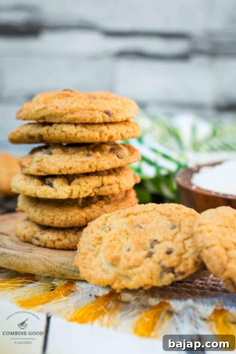 Delicious coconut chocolate chip cookies, stacked on a wooden plate.